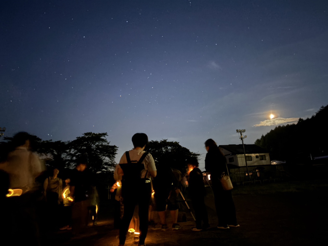 参加者が屋外で星空を観察している様子